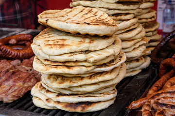 Home made pita bread displayed with different types of meat, for sale at a street food market