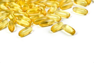 Close up of gold fish oil capsules pills isolated on white background. Supplementary food background view. Salmon fish capsules with Copy space. Omega 3 with Vitamin E.