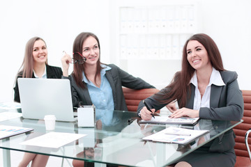 Fototapeta premium Three Businesswomen Meeting Around Table In Modern Office