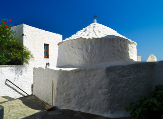 Beautiful picturesque white chapel in Patmos Island, Greece. Blue sky white paint contrast. Typical Greek island architecture.