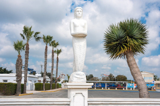 Mermaid statue in the park among palm trees