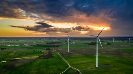 Fototapeta na wymiar Flying above wonderful wind turbines at dusk