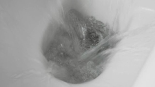 White toilet bowl in a bathroom. Closeup. Flush water away