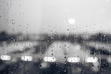 Water droplet on clear glass window from rain and summer storm or rainy season in the office city...