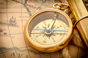 Fototapeta na wymiar compass with spyglass on old map