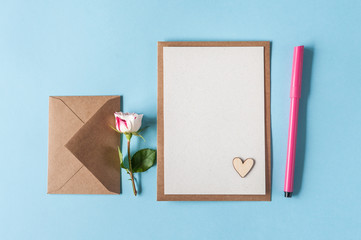  Blank card with rose and felt pen on blue background. Holiday concept. Love confession note....