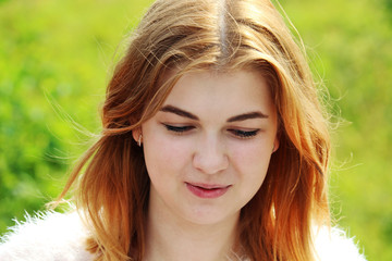 A thoughtful young girl sitting outside in summer