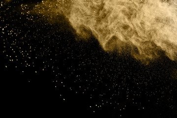 Plakat Golden powder explosion on black background. Freeze motion.