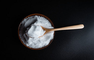 a spoonful of fine salt on a black background
