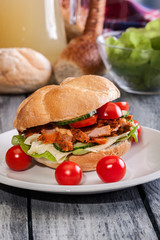 Fried chicken meat with cheese and vegetables in bun