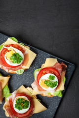 Delicious sandwich with prosciutto ham, cheese, tomato and egg