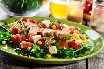 Fresh salad with chicken breast, arugula and tomato
