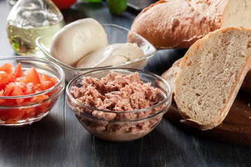 Ingredients ready for preparing bruschetta with tuna, mozzarella cheese and tomatoes