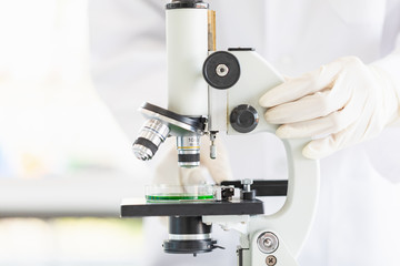 Scientist look through microscope for experiment..