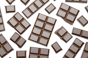Dark organic chocolate pieces isolated on white background