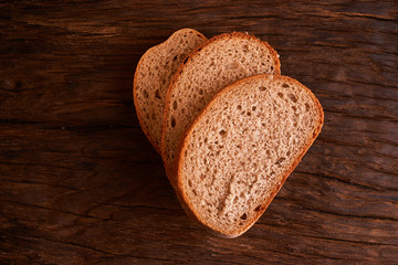 bread on dark wooden table. Bread slices and crumbs viewed from above. Top view