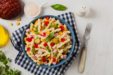 Italian fusilli pasta in a salad with ham and vegetables.