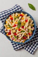 Italian fusilli pasta in a salad with ham and vegetables.