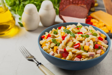 Italian fusilli pasta in a salad with ham and vegetables.