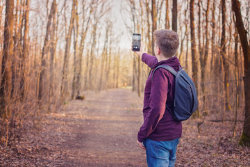 Child hiking in the woods and taking photos