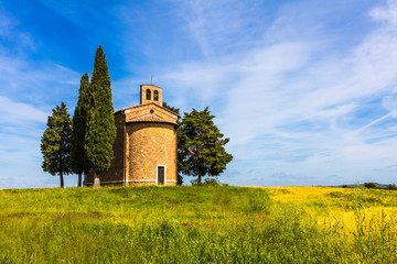Fototapeta na wymiar Tuscany church surrounded by cypresses