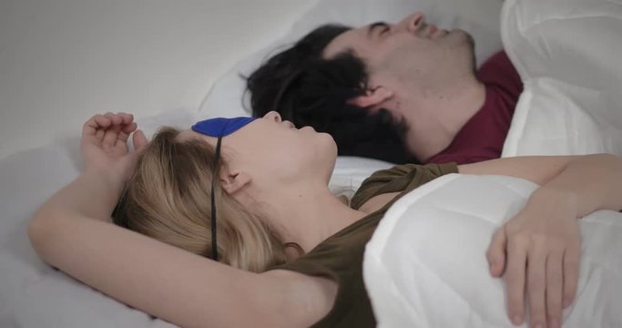 Man is trying to fall asleep while woman is snoring