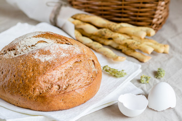 rye bread or sliced bread on white napkin with spike of wheat, eggshell and flour