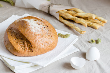 rye bread or sliced bread on white napkin with spike of wheat and eggshell