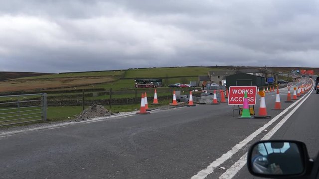 Car point of view driving past road works on A628 in Peak District, England, United Kingdom
