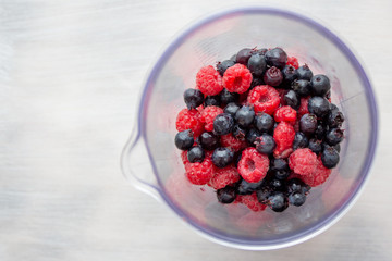 Shadberry and raspberry in measuring glass. Grinding berries.