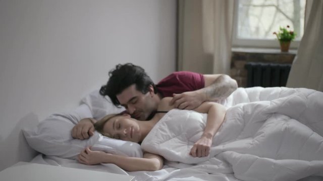 Happy couple waking up with mobile alarm clock - Image