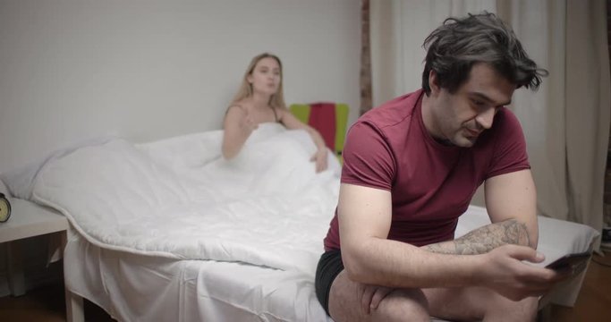 Man using smartphone and ignoring his wife