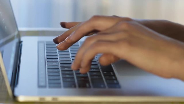 Female hands typing on laptop keyboard. Close-up