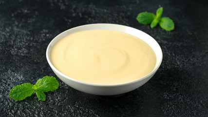 Bowl of vanilla custard on rustic background