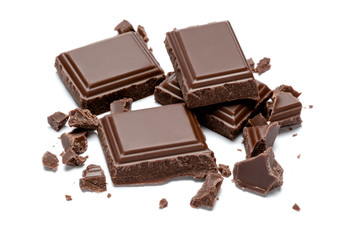 Dark organic chocolate pieces isolated on white background