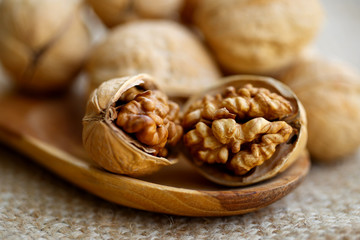 walnuts in wood spoon  on ramie sheet