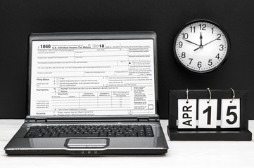 Laptop with tax form on screen and date of 15 april at the work place. Tax concept.
