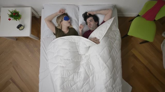 Annoyed man cannot sleep because of noise of wife snoring