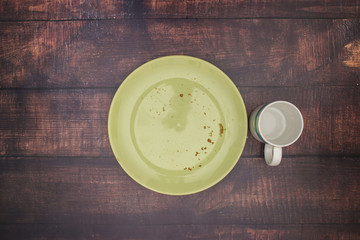 Bread with jam on green plate and cup of milk for breakfast