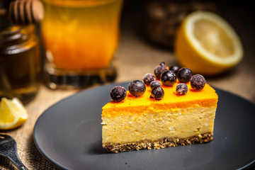 A slice of cheesecake with berries on a dark plate