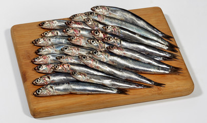 Fresh Anchovies fish on wooden cutting board