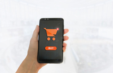 Hand holding mobile smart phone with my shopping carts screen on Supermarket blur background