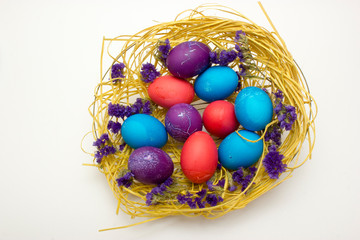 Fototapeta na wymiar Colored chicken eggs in nest on white background. Preparing celebrating Easter