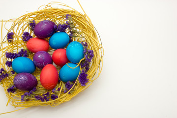 Fototapeta na wymiar Colored chicken eggs in nest on white background. Preparing celebrating Easter