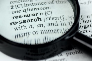 Close Up of Specific Word Research in a Dictionary with Loupe