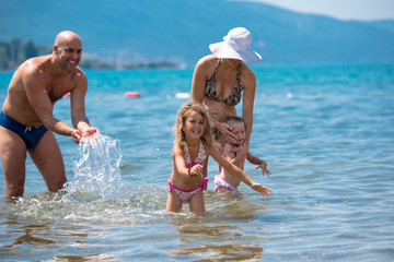 happy family splashing each other at beach