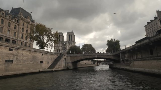 Point of view from a boat cruise tourist on Seine River Bridge of Notre Dame cathedral gothic catholic church Paris, France 