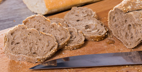 slices of wheaten bread and knife on wooden surface