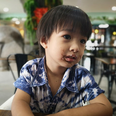 The boy had ate a chocolate stain on his mouth.