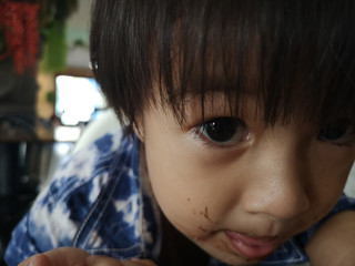 The boy had ate a chocolate stain on his mouth.